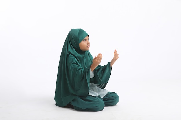 Fille religieuse islamique indienne priant sur fond blanc