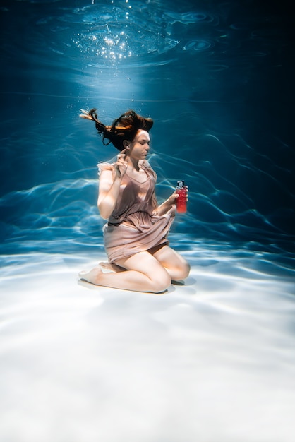 Photo fille de remise en forme avec smoothie coloré. fraîcheur sous l'eau, nage et plonge.