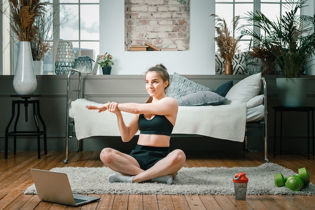 Une fille de remise en forme sportive forte et belle en tenue de sport médite en position du lotus