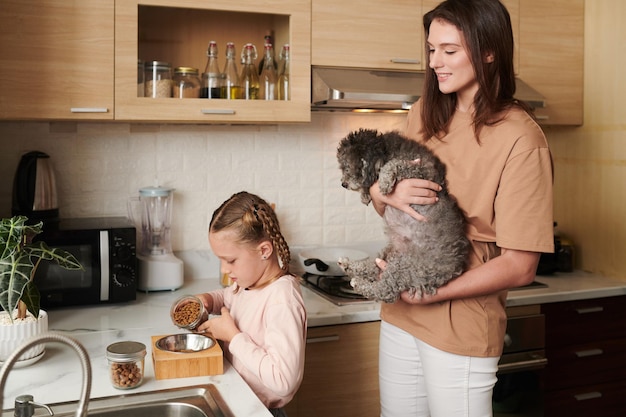 Fille remplissant un bol avec de la nourriture pour chien