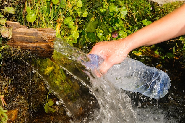 La fille remplit la bouteille d'eau