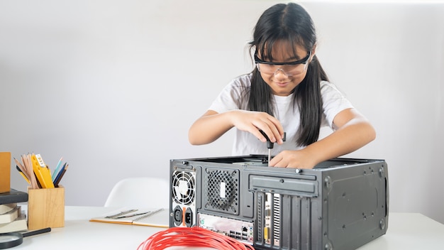 fille répare le matériel informatique au bureau de travail blanc moderne.