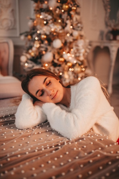 Photo fille rêvant sous le sapin de noël