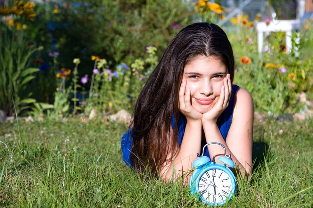 Fille avec réveil bleu en été