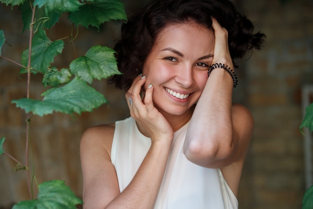 fille de rêves mignons avec des cheveux bouclés courts. portrait de femme émotive souriante sur la rue de la ville en journée ensoleillée. heureux, jeune, womans, figure, Dehors