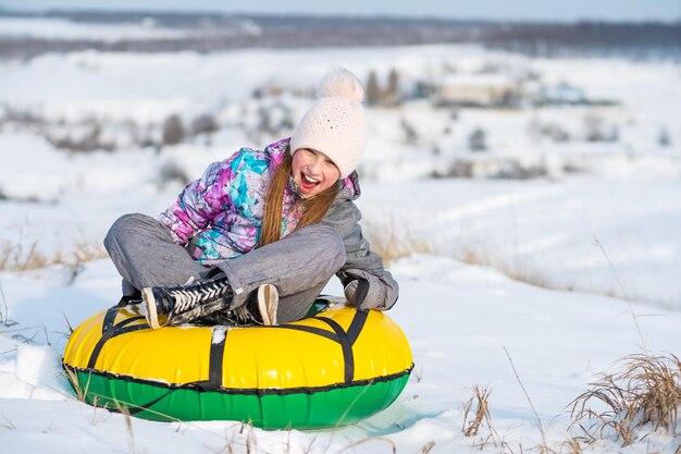 Fille riant en faisant du snow tubing