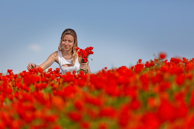 Fille en robe blanche dans le champ de coquelicots