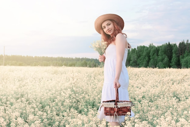 Fille en robe blanche dans le champ de fleurs jaunes en fleurs