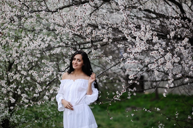 Fille en robe blanche sur fond de fleurs