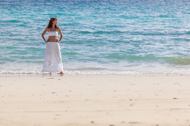 Fille en robe blanche sur la plage