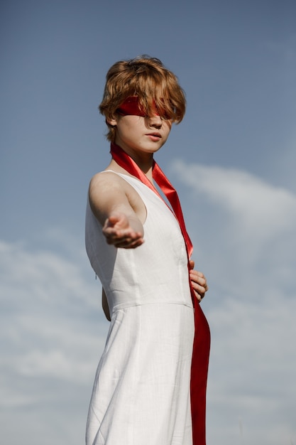 Fille en robe blanche avec un ruban rouge