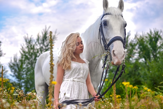 Fille En Robe Blanche Tenant Un Cheval Dans Le Champ