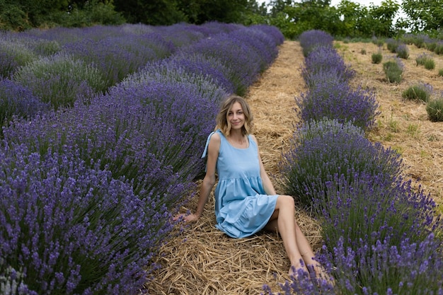 Fille en robe bleue dans un champ de lavande tourné en été