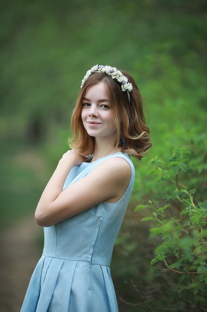 Fille en robe bleue dans un parc verdoyant