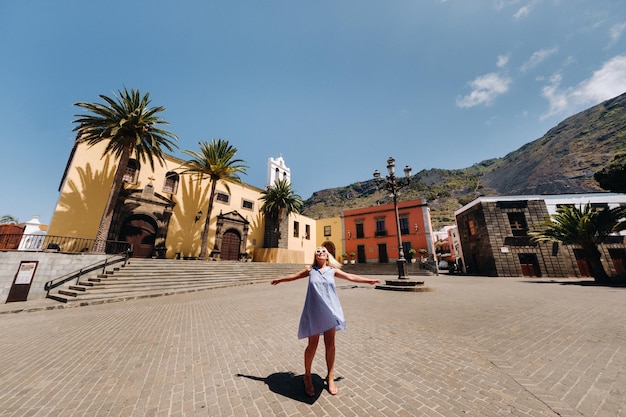 Une fille en robe bleue se promène dans la vieille ville de Garachico sur l'île de Tenerife lors d'une journée ensoleillée en Espagne