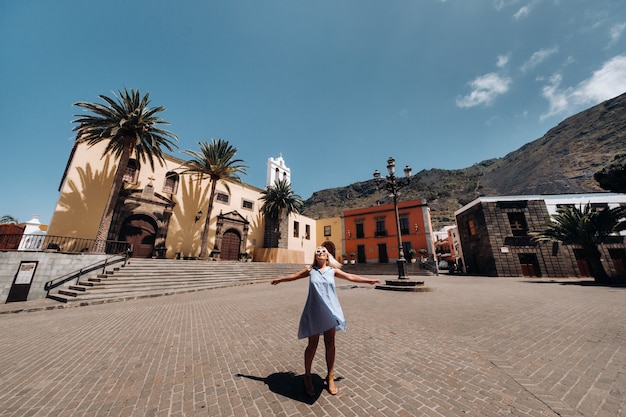 Une fille en robe bleue se promène dans la vieille ville de Garachico sur l'île de Tenerife par une journée ensoleillée