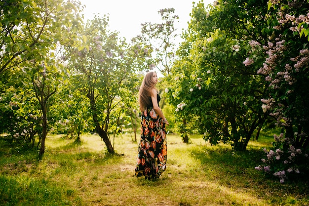 Une fille en robe fleurie dans la nature