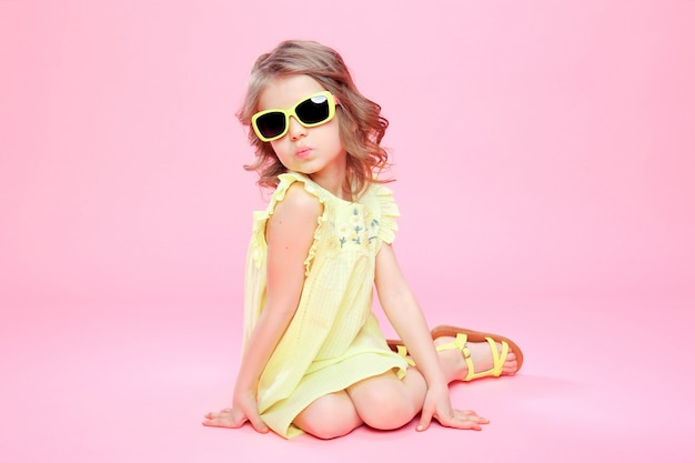 Fille en robe jaune et lunettes de soleil