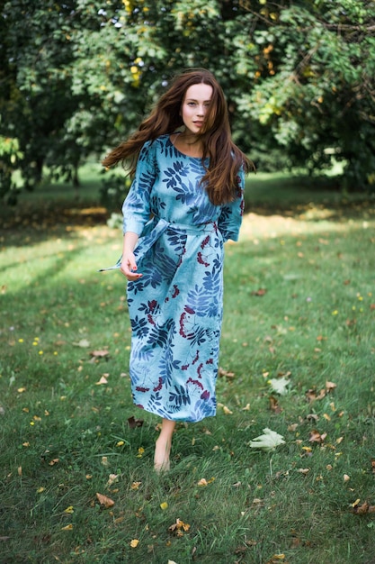 fille en robe en lin. avec une guirlande de fleurs sur sa tête.