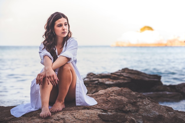 Fille avec une robe noire dans la mer sur la côte basque