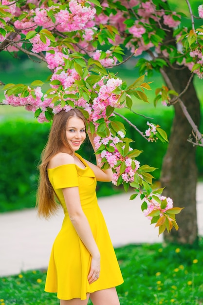 Fille en robe posant pour la caméra dans le parc