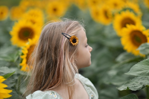 Une fille en robe profite de la vie dans un champ avec des tournesols