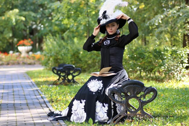 Fille en robe rétro siècle passé lire la lettre sur le banc