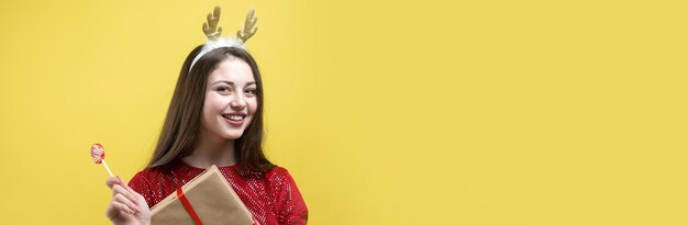 Une fille en robe rouge avec un cadeau sur fond jaune