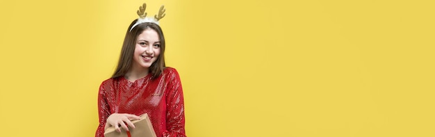 Une fille en robe rouge avec des cadeaux sur fond jaune