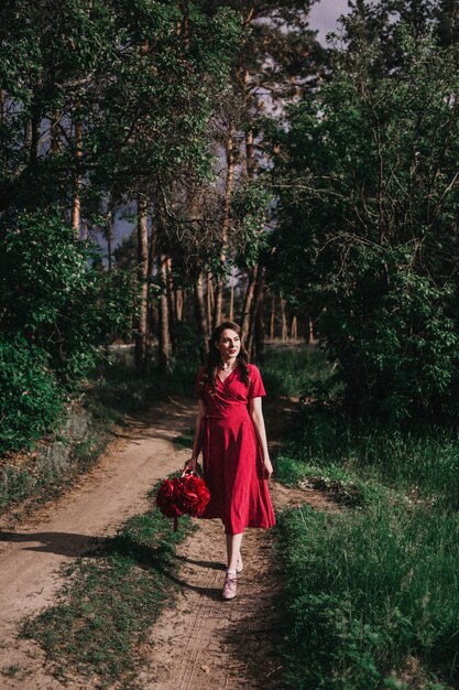 Fille en robe rouge dans la forêt