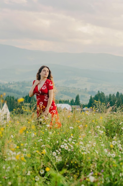 Une fille en robe rouge lors d'une promenade dans une région montagneuse