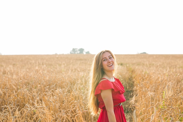 Fille en robe rouge sur le terrain. Vue arrière