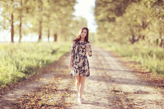 Fille en robe sur la route d'été