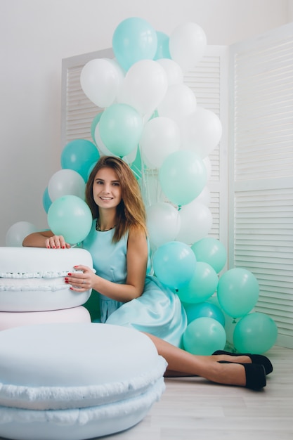 Fille en robe turquoise avec des ballons