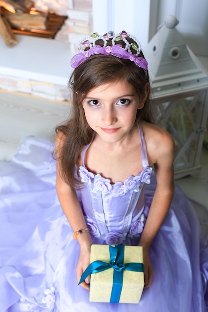 La fille à la robe violette tenant un cadeau de Noël