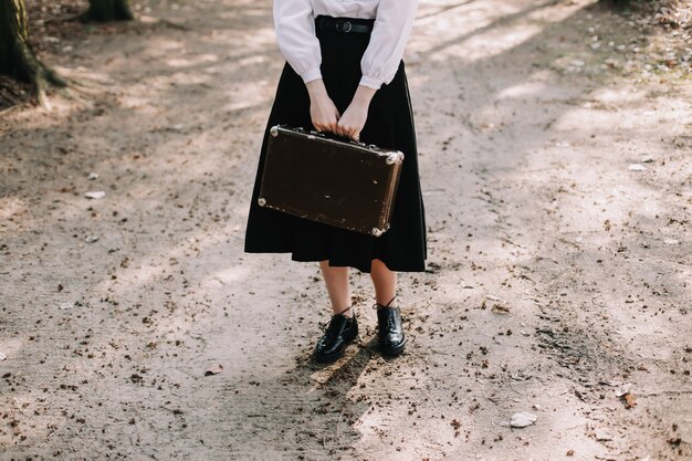 fille romantique avec une valise vintage dans le concept de voyage vacances aventure parc