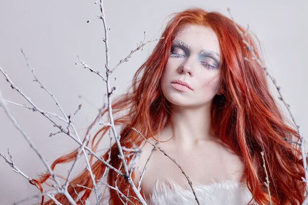 Fille rousse aux cheveux longs, un visage couvert de neige avec du givre.