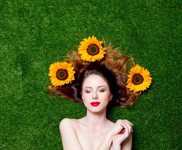 fille rousse aux tournesols sur l&#39;herbe