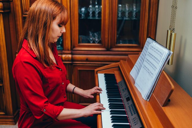 Fille Rousse En Chemise Rouge Apprendre à Jouer Du Piano à La Maison