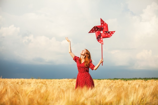 Fille rousse avec éolienne jouet