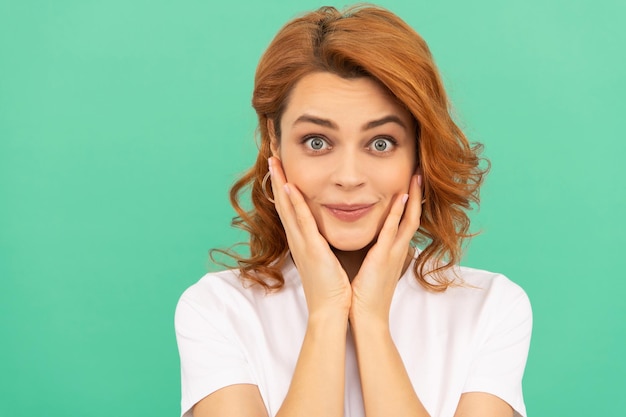 Fille Rousse étonnée Avec Une Peau Parfaite Et Des Cheveux Bouclés Sur Fond Bleu, Portrait De Beauté.