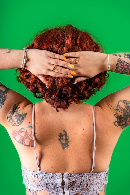 Fille rousse non binaire tatouée moderne par derrière