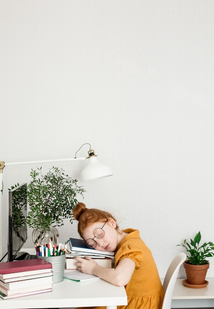 Une fille rousse s'est endormie pendant ses études.