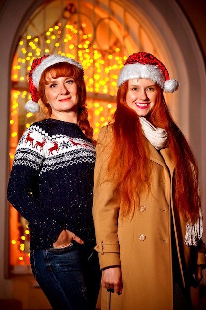 Photo fille rousse avec sa mère dans la soirée d'hiver dans la rue