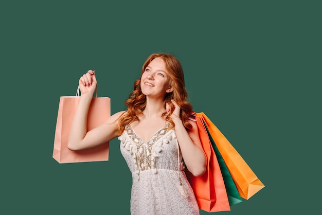 Fille rousse souriante avec des sacs à provisions