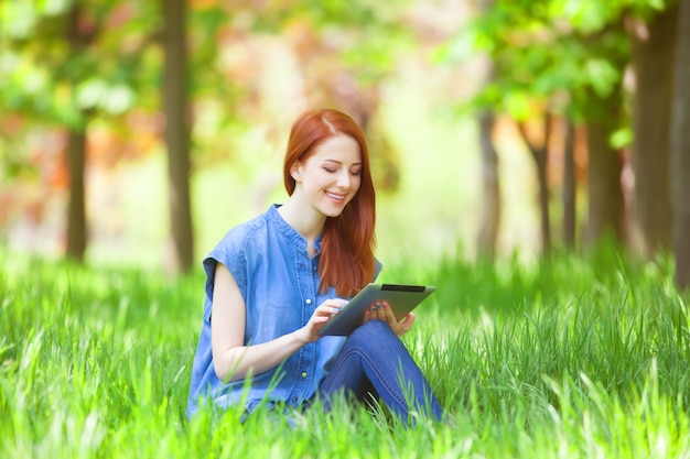 Fille rousse avec talet dans le parc