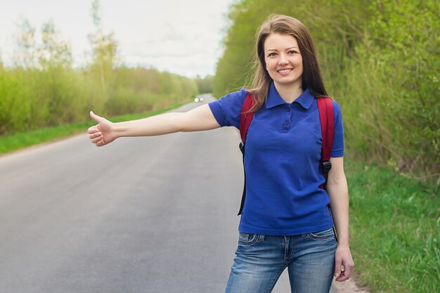 Fille sur la route arrêtant la voiture