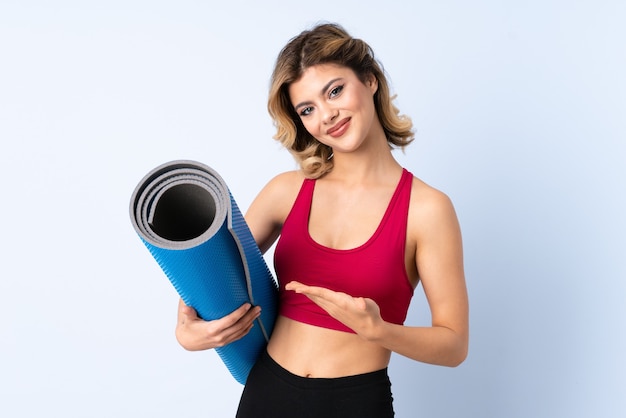 Fille russe avec tapis isolé sur mur bleu avec expression triste