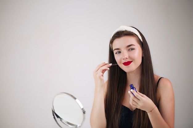 Fille s’admire, se regardant dans le miroir de près.