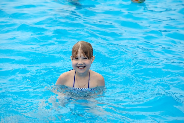 fille s'amusant à nager dans la piscine